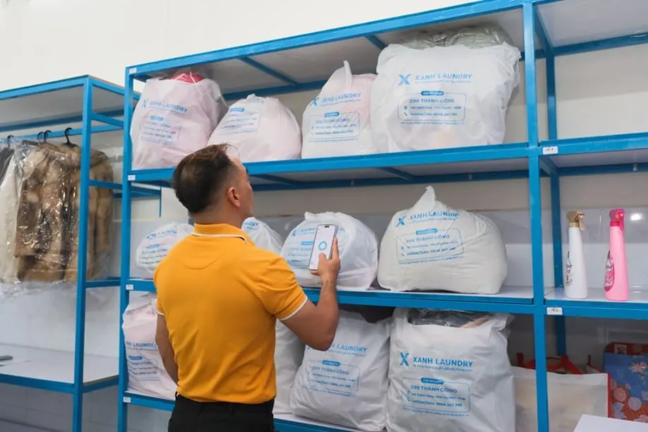 Nhân viên quét đơn TinyClean trên kệ đồ